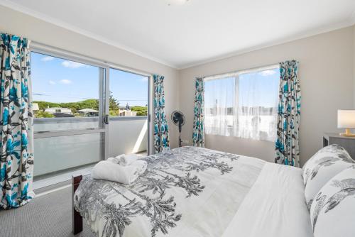 Oroua DownsHunia Haven - Himatangi Beach Holiday Home的一间卧室设有一张床和一个大窗户