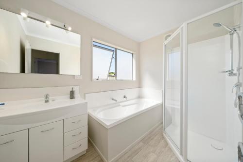 Oroua DownsHunia Haven - Himatangi Beach Holiday Home的白色的浴室设有2个盥洗盆和淋浴。
