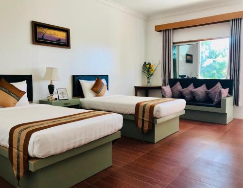 MyeneE-Outfitting Royal Inn Bagan的酒店客房设有两张床和窗户。