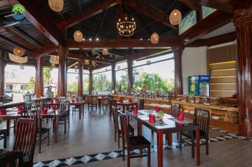 芹苴Cantho Eco Resort的用餐室设有桌椅和窗户。