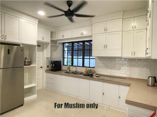 麻坡Alexis Villa的厨房配有白色橱柜和吊扇
