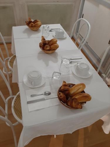 里摩日Hôtel Les Beaux Arts- Limoges Hypercentre的一张白桌子,上面放着一碗食物