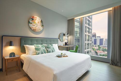 新加坡Citadines Raffles Place Singapore的卧室设有一张白色大床和大窗户