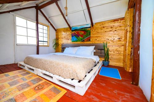 NyahururuOlrok Farm House的卧室配有一张床铺,位于带木墙的房间内