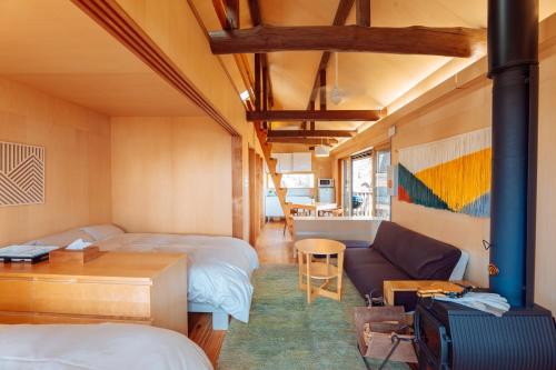 神户ROKKONOMAD的一间客房配有两张床和一张沙发