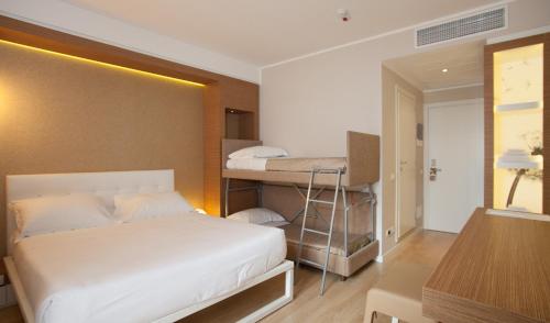 里米尼Oxygen Lifestyle Hotel的一间卧室配有两张双层床和一张书桌