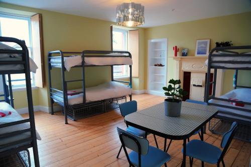 邓巴The Dolphin Inn Hostel的客房设有桌椅和双层床。