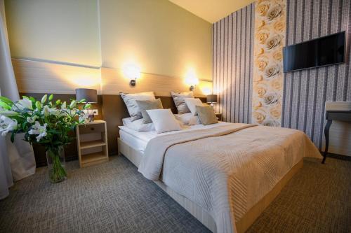 克拉科夫卡齐米三世酒店的配有一张床和花瓶的酒店客房