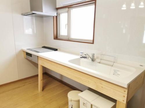 富良野All Seasons Furano Chalet的一间带白色水槽和窗户的浴室