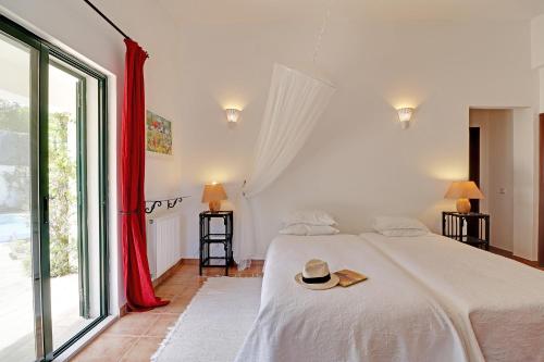 圣巴巴拉-迪内希Algarve Country Villa With Pool by Homing的一间卧室,配有一张床,上面有帽子