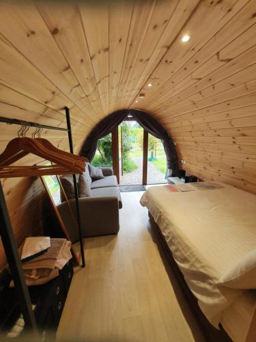 基拉尼Priory Glamping Pods and Guest accommodation的一间卧室配有一张床和一个沙发