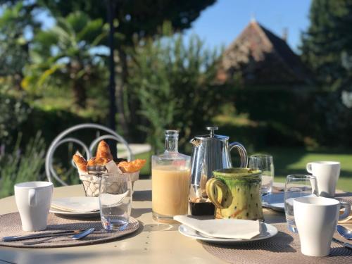 莱萨韦尼埃Domaine du Manoir的餐桌,早餐包括面包和牛奶