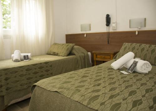 马德普拉塔Hotel Montreal的酒店客房设有两张床和电话