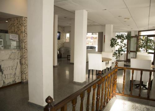 马德普拉塔Gran Hotel Manila的走廊上设有白色的柱子和桌椅