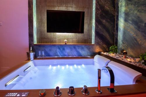 庞贝Pompei Luxury Rooms的带浴缸的浴室和电视