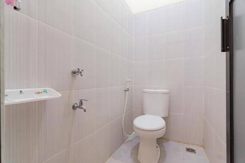 巴厘巴板RedDoorz near Arka Sepinggan Airport的白色的浴室设有卫生间和水槽。