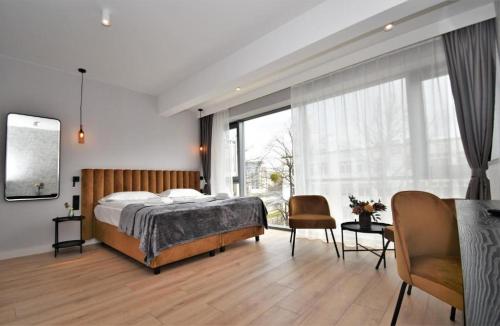 格但斯克Patio Riverfront Aparthotel的一间卧室设有一张床和一个大窗户