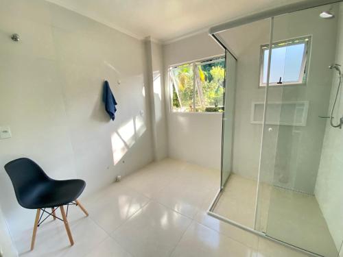 弗洛里亚诺波利斯Pousada Altas Natureza的一间带玻璃淋浴和椅子的浴室