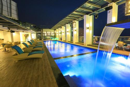 马六甲颐庭酒店的酒店游泳池设有椅子和喷泉