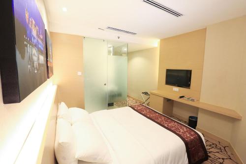 马六甲颐庭酒店的酒店客房,配有床和电视