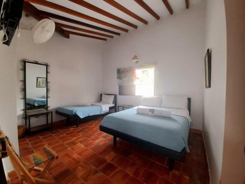 索科罗Hotel Villa Del Socorro的一间卧室设有两张床,墙上设有一面镜子