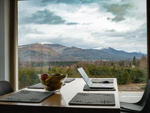韦特利纳Białe Chyże的一张桌子和一台笔记本电脑,享有山景
