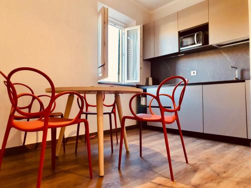 比萨The Square of Miracles Apartment的厨房配有木桌和四把椅子