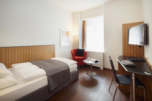 苏黎世吕特里索雷尔酒的酒店客房配有一张床和一张带电脑的书桌
