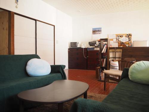 松江市Guest House SUETUGU的客厅配有两张绿色沙发和一张桌子