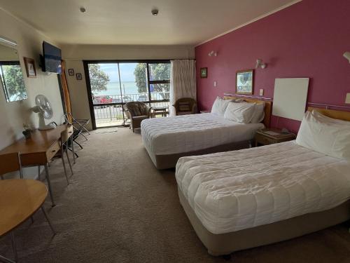 派西亚金沙湾海滨一室公寓的酒店客房设有两张床和一个阳台。
