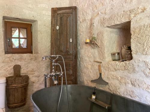 莫内斯捷Les 2 Brigards的一间石墙内带浴缸的浴室