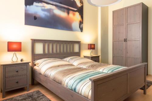 德累斯顿DD-洛博陶1公寓的一间卧室配有一张带2个床头柜和2盏灯的床。
