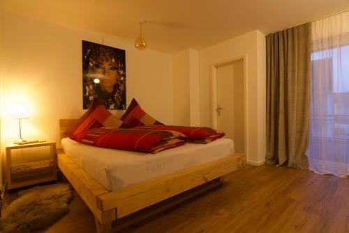 罗拉赫Ferienwohnung Dreiländereck 1的一间卧室配有红色枕头的床