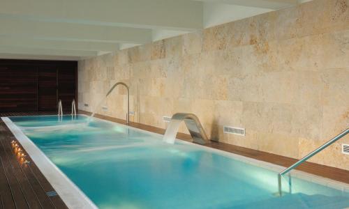 萨卡罗Hostal de la Gavina GL - The Leading Hotels of the World的大楼内一个蓝色的大型游泳池