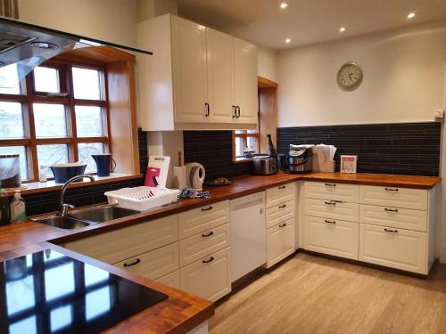 瑟伊藻克罗屈尔Helluland Guesthouse的厨房配有白色橱柜和水槽