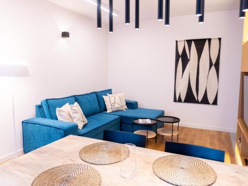 华沙Hello!Apartments Przy Arkadii的客厅配有蓝色的沙发和桌子