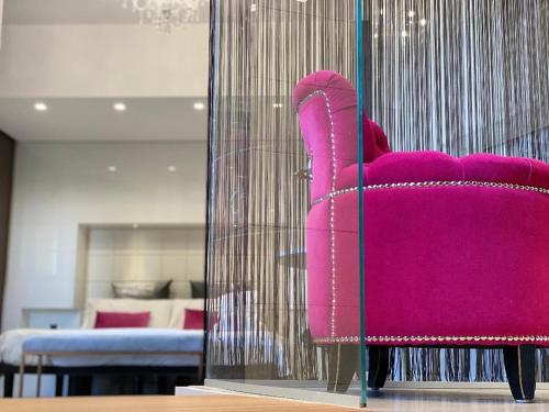 圣乔瓦尼·罗通多Gran Paradiso Hotel Spa的客厅里的粉红色椅子