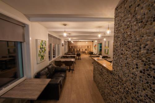 维克维克普费因酒店的餐厅设有长沙发和桌子,拥有石墙