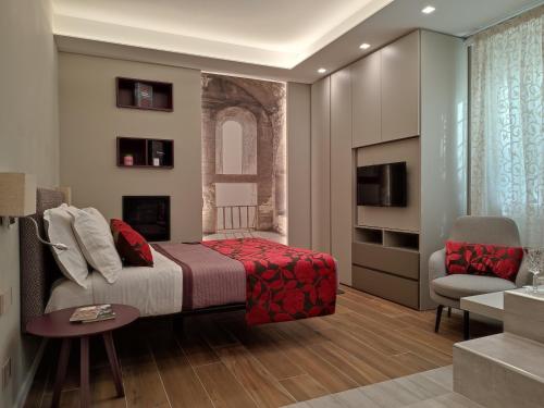 罗马il sogno di afrodite luxury b and b的一间卧室配有一张床、一把椅子和电视