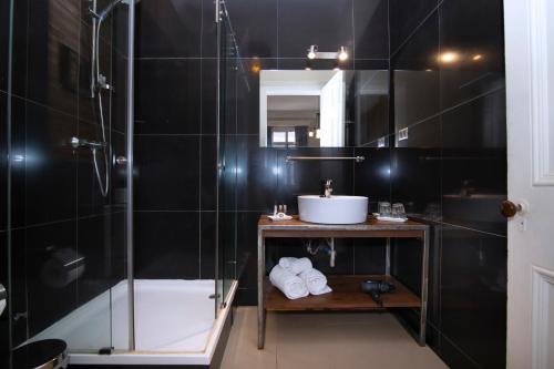 瓦尔帕莱索New Voga Guesthouse的带淋浴和盥洗盆的浴室