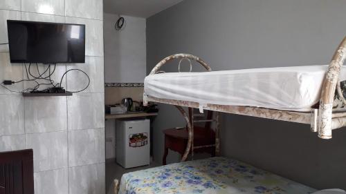 萨利纳斯Habitacion Vacacional Camboriu的卧室配有双层床,墙上配有电视