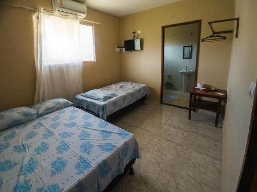 佩罗巴Casa Morada da Praia 2的客房设有两张床和一间带镜子的浴室