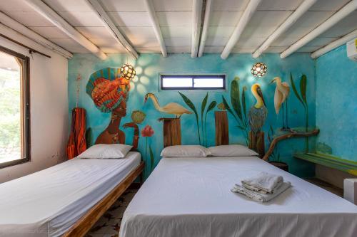 科韦尼亚斯Mar Amar Cabaña - Hostel的墙上画画的房间里设有两张床