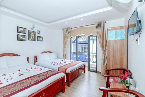 大叻Moc Nhien Hostel Da Lat的酒店客房设有两张床和一个阳台。
