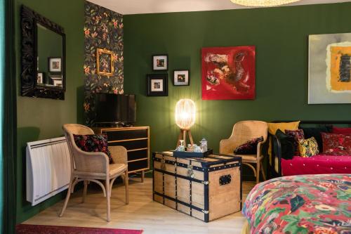 武夫赖Les Patis的一间卧室设有绿色的墙壁和一张床及椅子