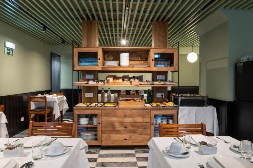里斯本Blue Liberdade Hotel的一间设有两张桌子的餐厅和一个提供食物的柜台