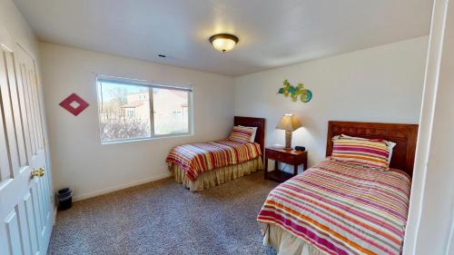 摩押Desert Hideaway #C2的一间卧室设有两张床和窗户。