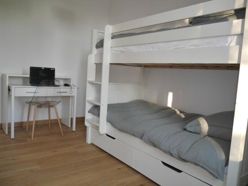 奥赛Spacieux F5 au parc arboré的一间卧室配有两张双层床和一张书桌