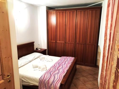 梅扎纳Apartment "Casa Maya"的一间卧室配有一张床和一个木制橱柜