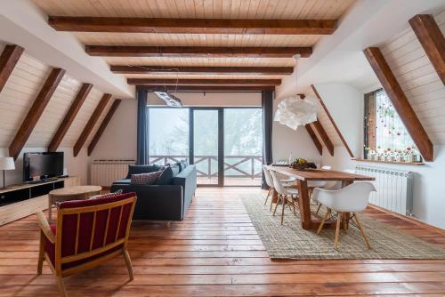 科帕奥尼克Vista Mountain House的客厅铺有木地板,配有桌子。
